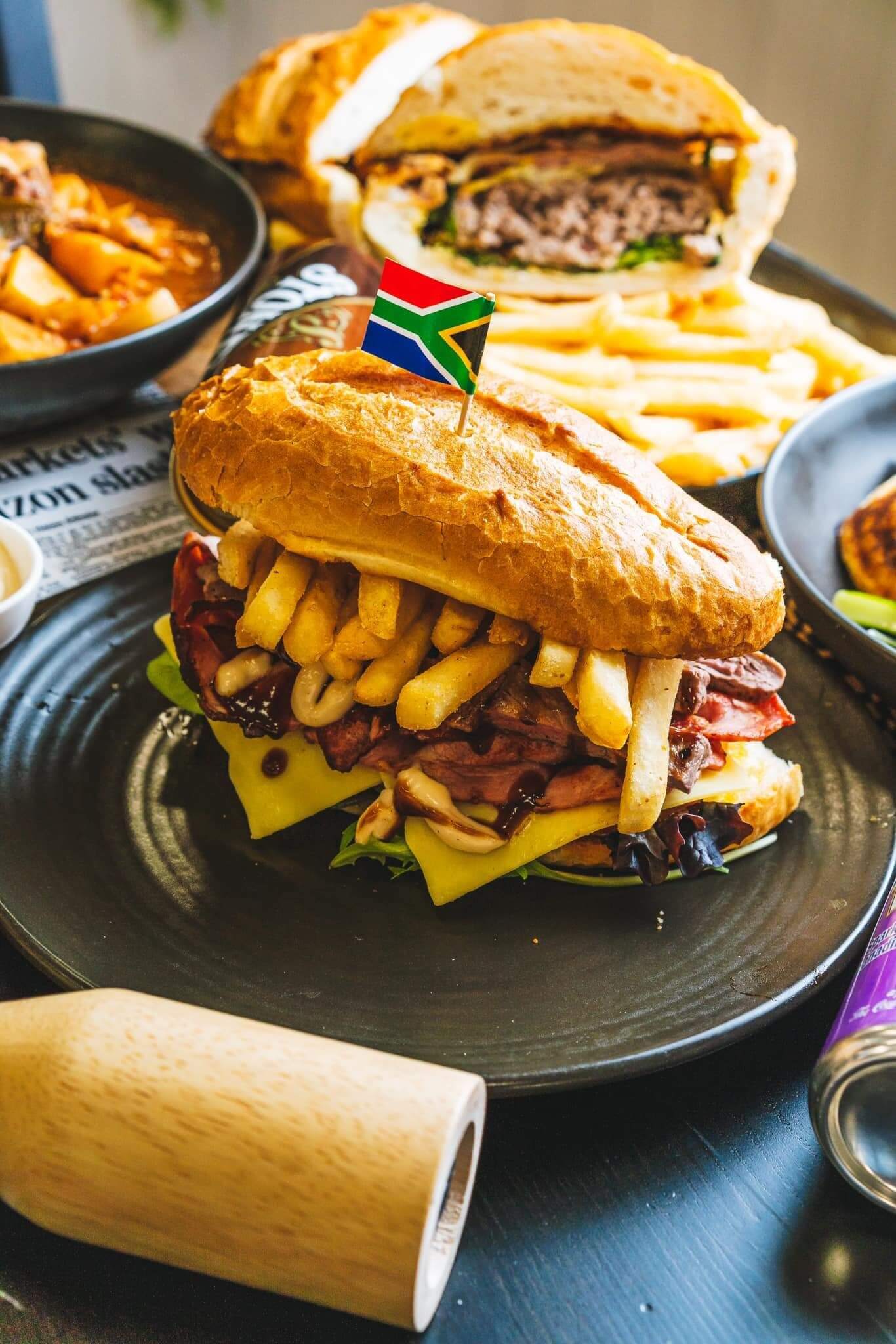 Plates of burgers filled with chips, lettuce, meat